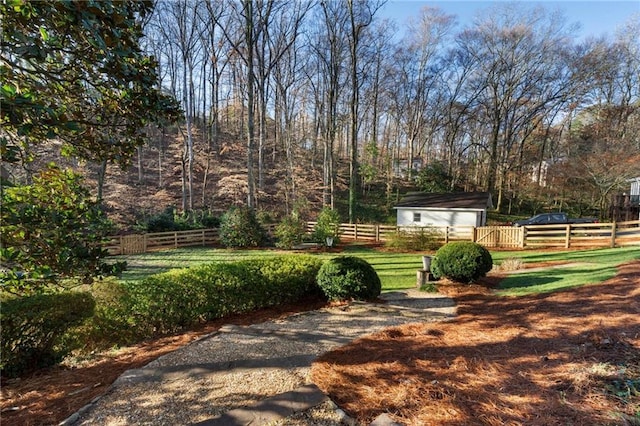 view of yard with a garage, an outdoor structure, and fence