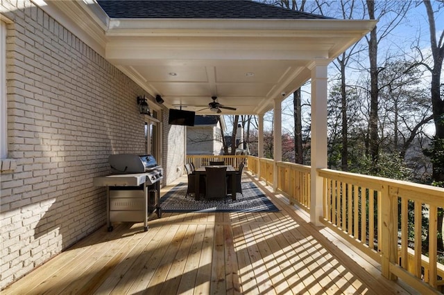 wooden terrace with outdoor dining space, area for grilling, and ceiling fan