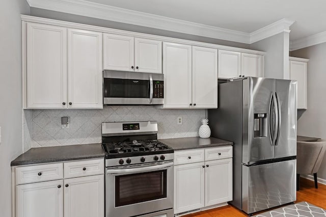 kitchen featuring white cabinetry, appliances with stainless steel finishes, backsplash, and crown molding