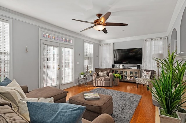 living room with a wealth of natural light, hardwood / wood-style floors, ceiling fan, and french doors