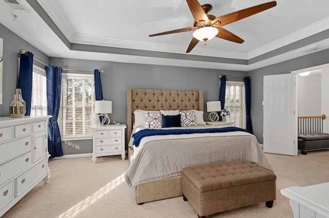 bedroom with light carpet, ceiling fan, and a tray ceiling