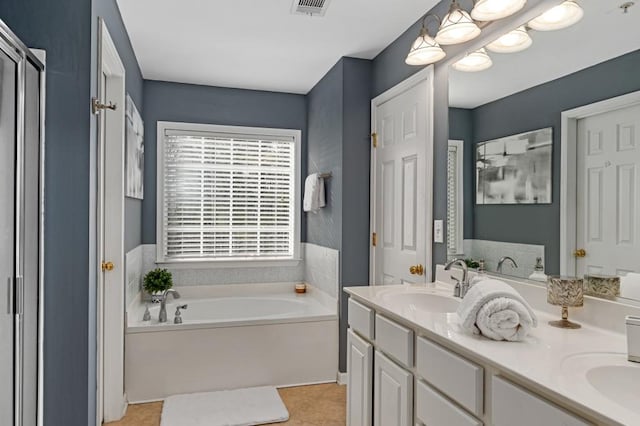 bathroom with vanity, tile patterned flooring, and a tub