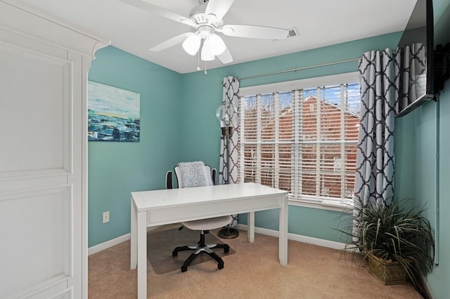 carpeted home office featuring ceiling fan