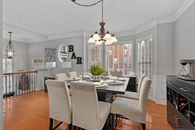 dining room featuring ornamental molding, a chandelier, and light hardwood / wood-style floors