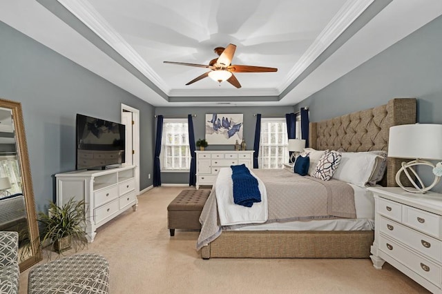 carpeted bedroom featuring crown molding, ceiling fan, and a raised ceiling