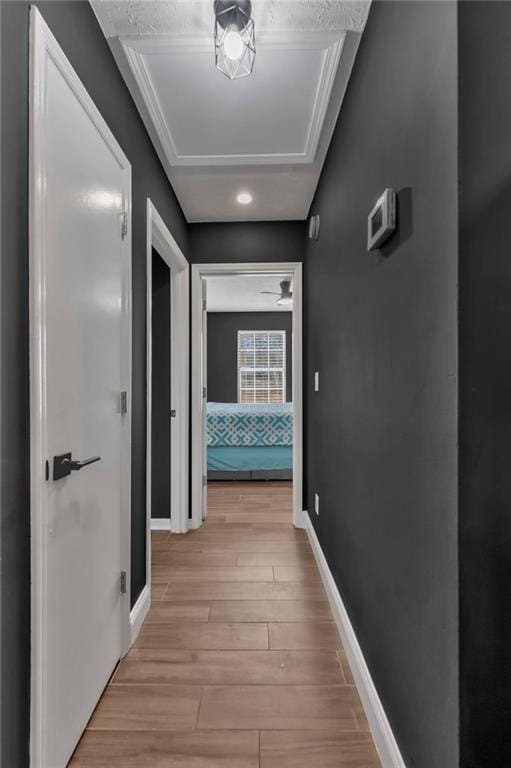 corridor featuring light wood-type flooring and baseboards