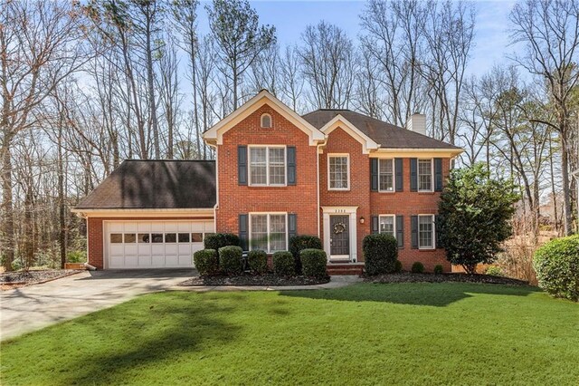 colonial home with a garage and a front yard