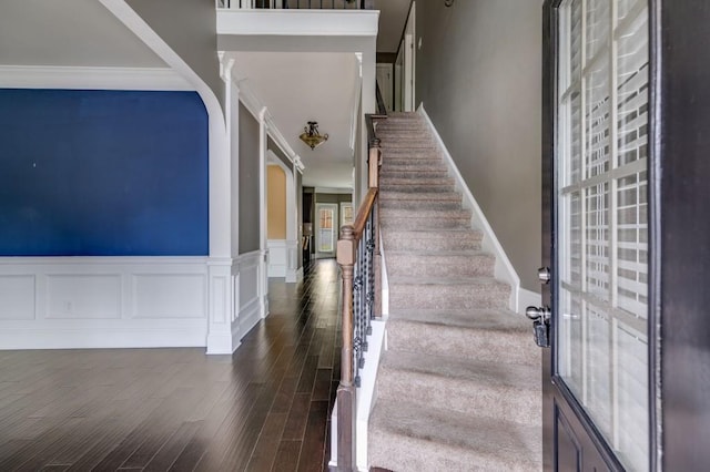 staircase with crown molding and wood-type flooring