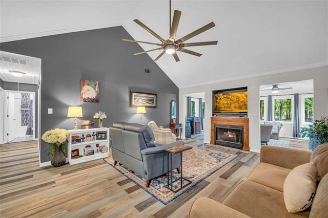 living room featuring crown molding, light hardwood / wood-style flooring, and high vaulted ceiling