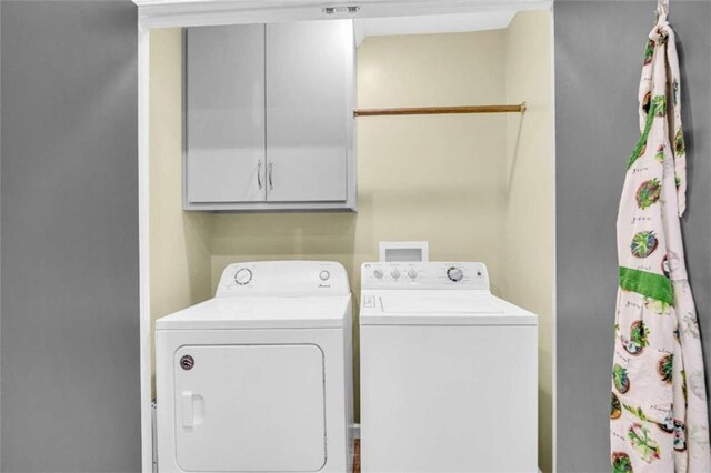 washroom featuring washer and clothes dryer and cabinets