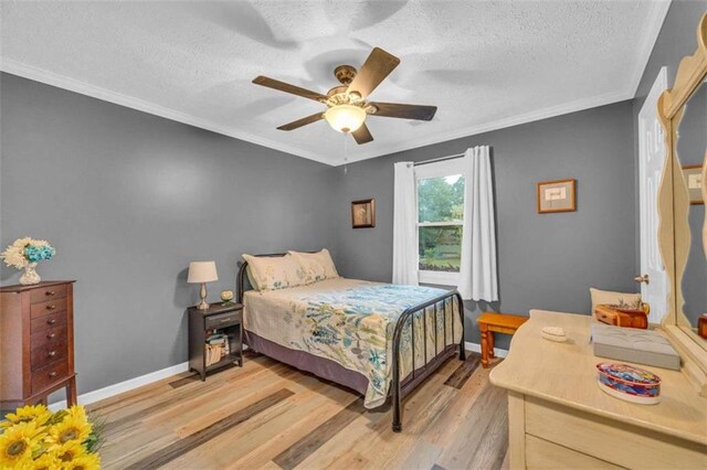 bedroom with ceiling fan, light hardwood / wood-style flooring, crown molding, and a textured ceiling