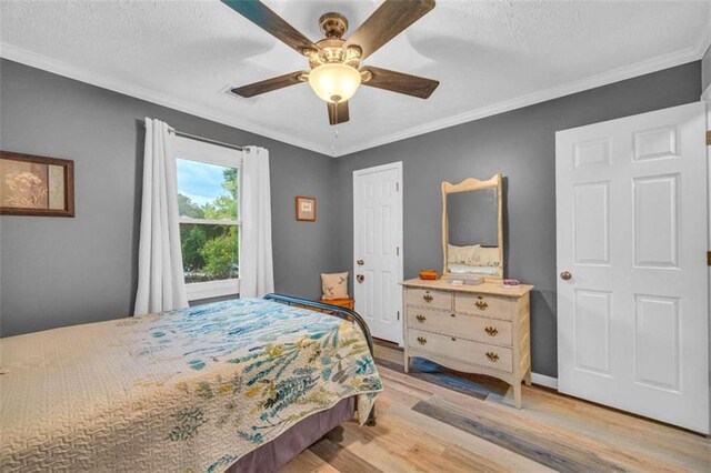 bedroom with a textured ceiling, light hardwood / wood-style floors, ceiling fan, and ornamental molding