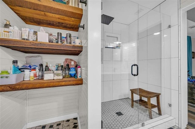 bathroom with a shower with door and tile walls