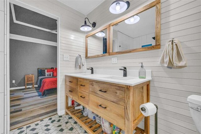 bathroom with hardwood / wood-style flooring, vanity, toilet, and wooden walls