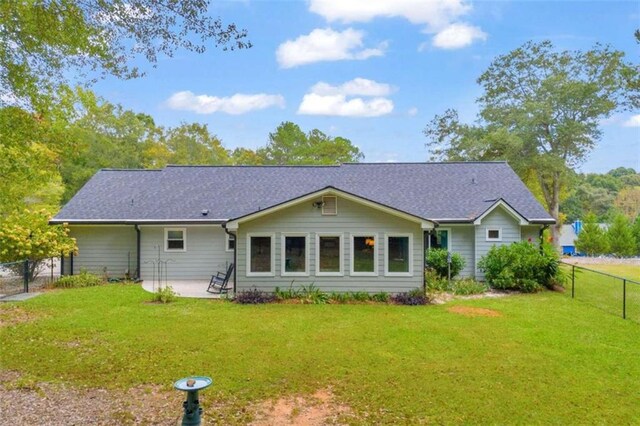 rear view of property featuring a patio and a lawn