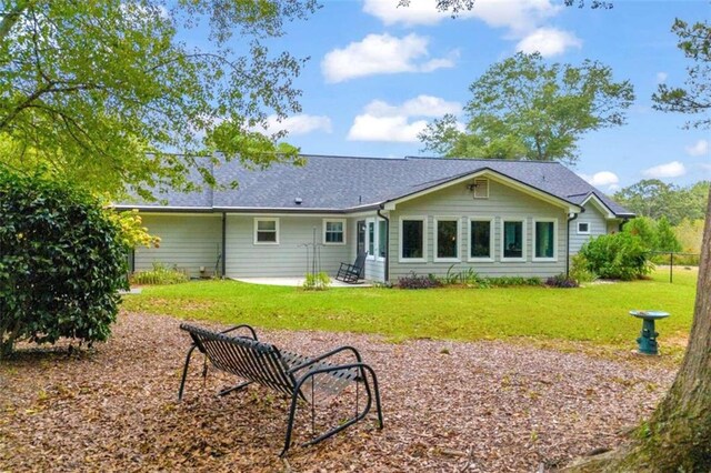 back of property with a lawn and a patio area