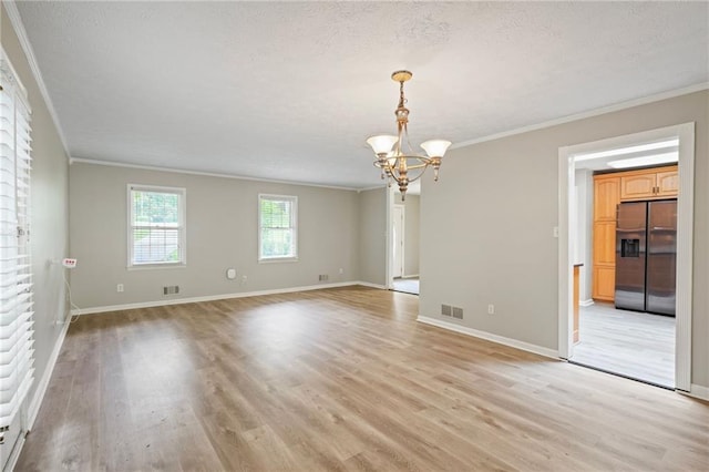 unfurnished room featuring light hardwood / wood-style floors, a notable chandelier, and crown molding