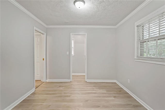 unfurnished bedroom with a closet, light wood-type flooring, a walk in closet, ornamental molding, and a textured ceiling