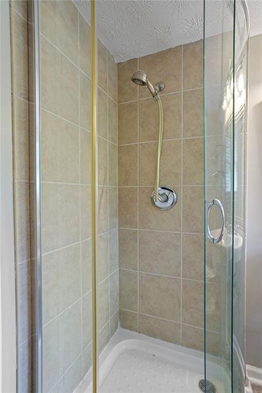 bathroom featuring walk in shower and a textured ceiling