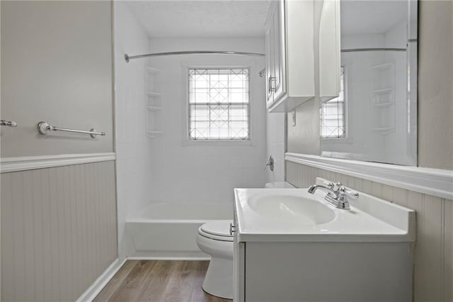 full bathroom with shower / bath combination, hardwood / wood-style floors, a textured ceiling, toilet, and vanity