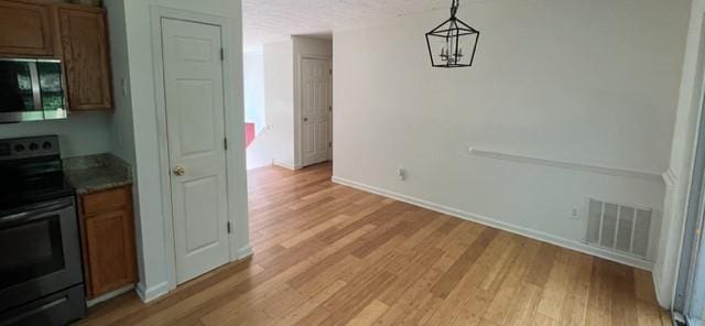 unfurnished dining area with light wood-style flooring and baseboards