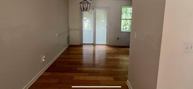empty room featuring wood finished floors and baseboards