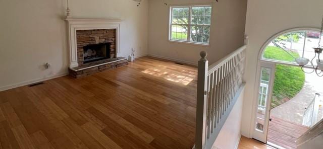 unfurnished living room with plenty of natural light, wood finished floors, and a fireplace