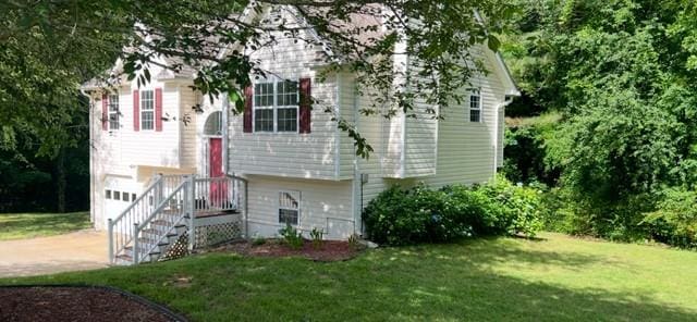 view of front of property with driveway, a front lawn, and an attached garage