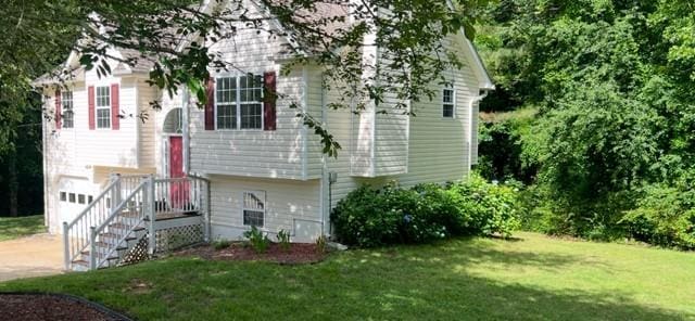 split foyer home featuring a front yard, concrete driveway, and an attached garage