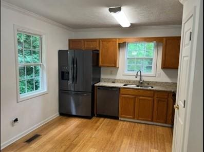 279 Fairview Dr, Dallas, GA 30157 - kitchen with black fridge, dishwasher, a sink, brown cabinets, and crown molding