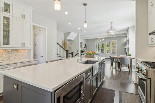 823 Canterbury Overlook, Atlanta, GA 30324 - kitchen featuring tasteful backsplash, a sink, appliances with stainless steel finishes, a kitchen island with sink, and white cabinetry