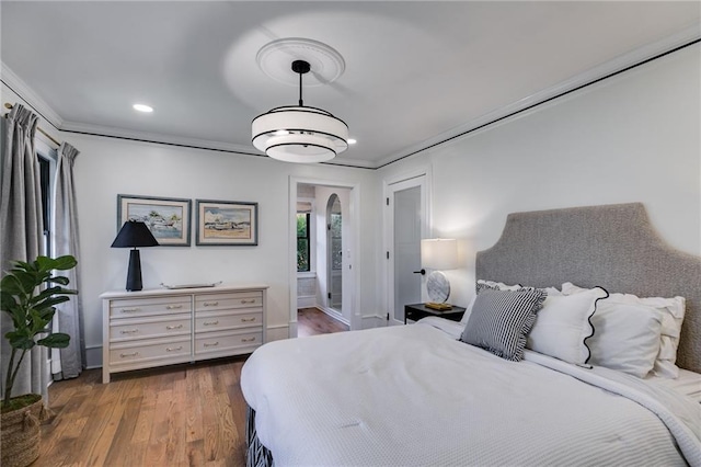 bedroom with crown molding and dark hardwood / wood-style floors