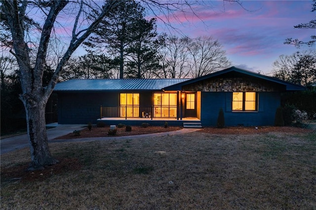 single story home with a yard and a porch