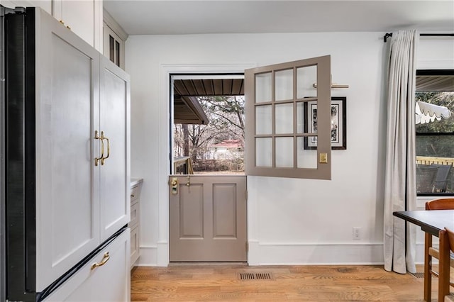 doorway with a healthy amount of sunlight and light wood-type flooring