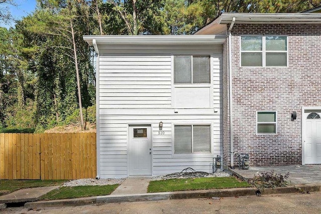 view of front of property featuring brick siding and fence