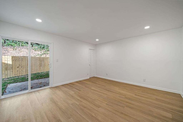 spare room featuring baseboards, wood finished floors, and recessed lighting