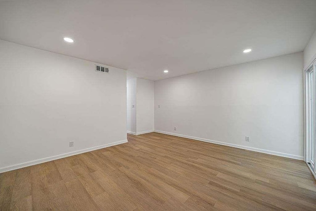 unfurnished room featuring visible vents, baseboards, and wood finished floors