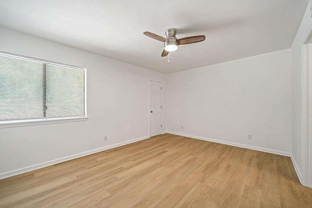 spare room featuring baseboards, ceiling fan, and light wood-style floors