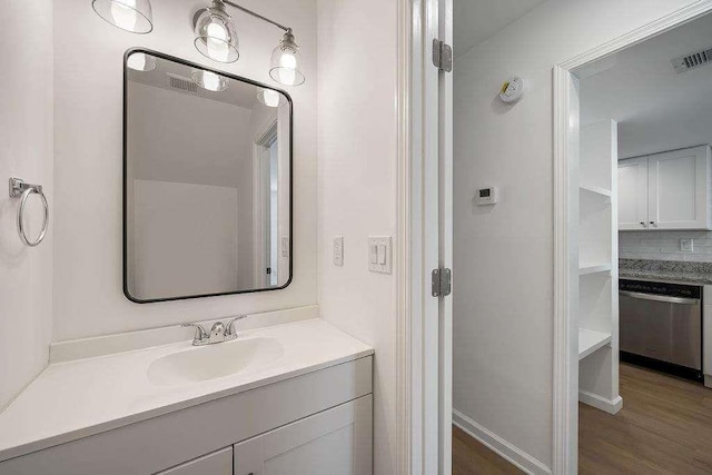 bathroom with visible vents, wood finished floors, backsplash, and vanity