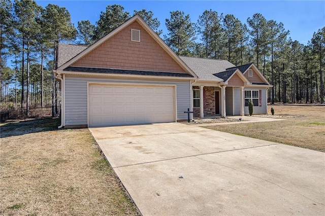 craftsman house featuring a garage and a front lawn