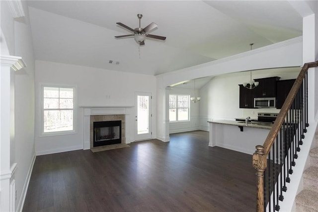 unfurnished living room with dark hardwood / wood-style floors, a fireplace, lofted ceiling, sink, and ceiling fan