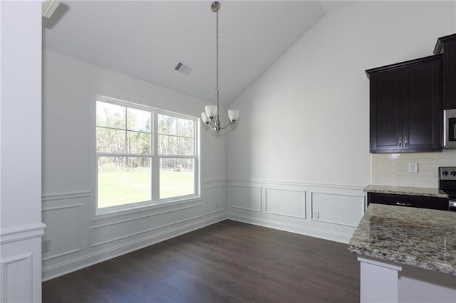 unfurnished dining area with lofted ceiling, dark wood-type flooring, and a chandelier