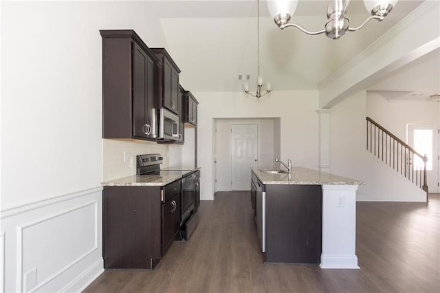 kitchen with sink, an inviting chandelier, a kitchen island with sink, stainless steel appliances, and decorative light fixtures