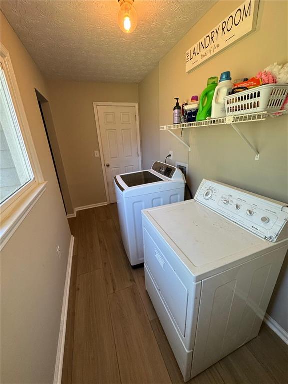 190 Grayland Creek Dr, Lawrenceville, GA 30046 - laundry room with washing machine and clothes dryer, wood finished floors, baseboards, and a textured ceiling