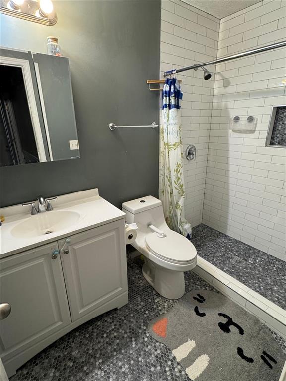 190 Grayland Creek Dr, Lawrenceville, GA 30046 - bathroom featuring tiled shower, toilet, and vanity