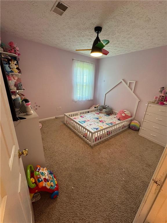 190 Grayland Creek Dr, Lawrenceville, GA 30046 - bedroom with a textured ceiling, carpet floors, a ceiling fan, and baseboards