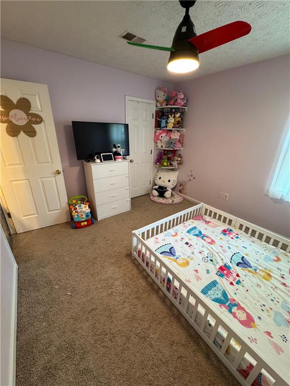 190 Grayland Creek Dr, Lawrenceville, GA 30046 - carpeted bedroom featuring a textured ceiling and a ceiling fan