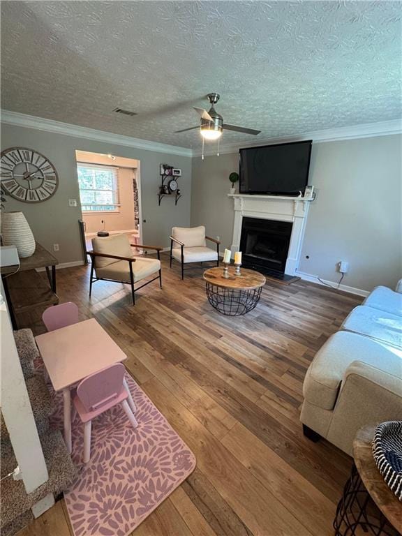 190 Grayland Creek Dr, Lawrenceville, GA 30046 - living area with wood-type flooring, a ceiling fan, ornamental molding, a fireplace with flush hearth, and a textured ceiling