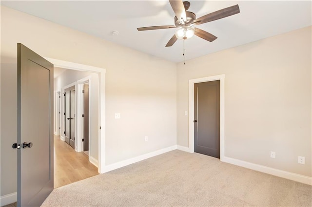 unfurnished room featuring ceiling fan and light colored carpet