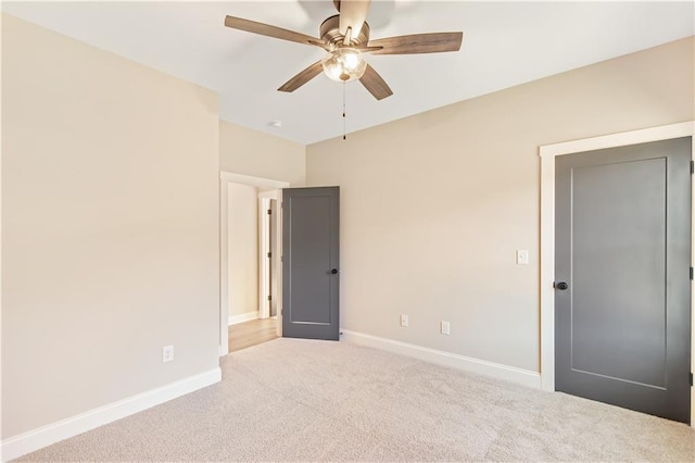 empty room featuring light carpet and ceiling fan